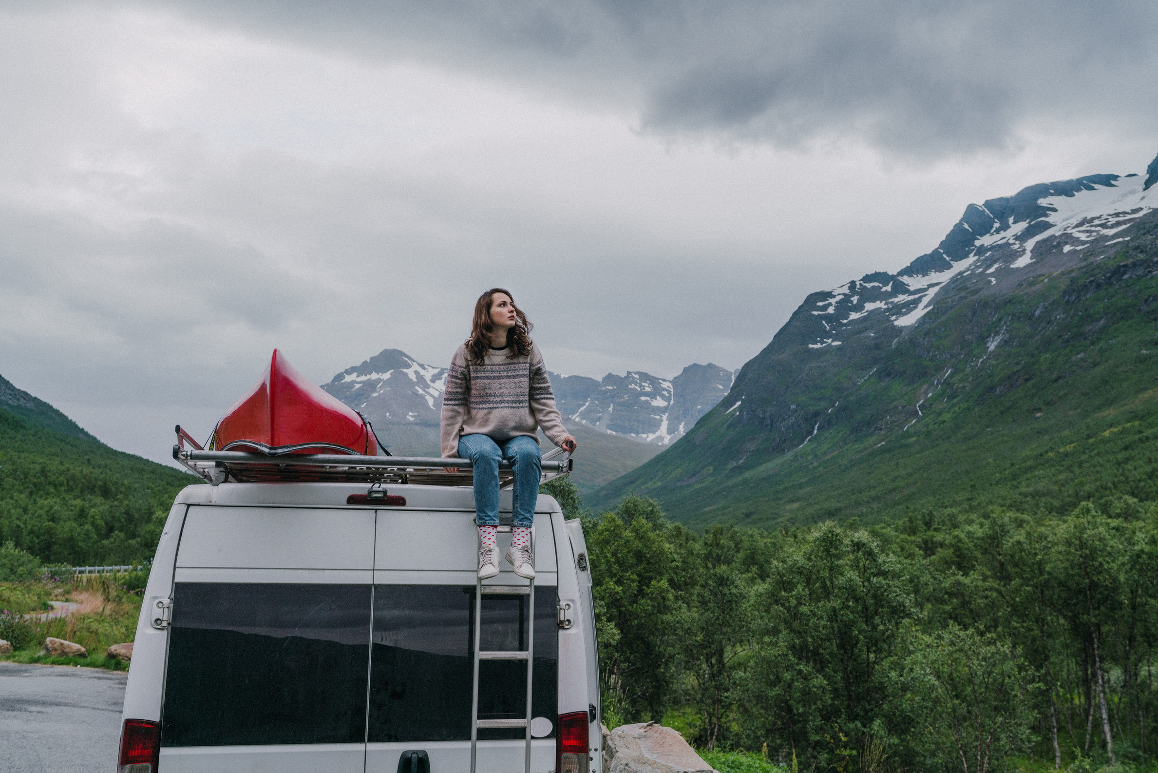 Woman sitting  on roof of camper van